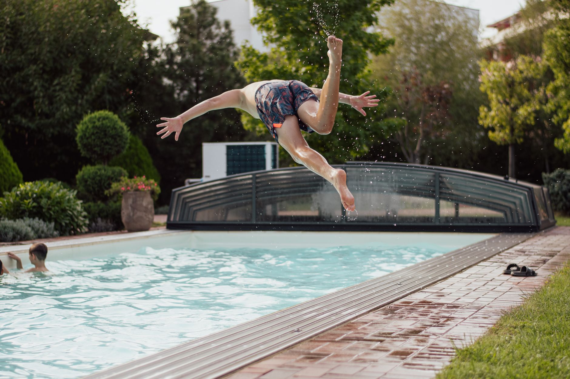 Enfant qui saute dans une piscine de jardin