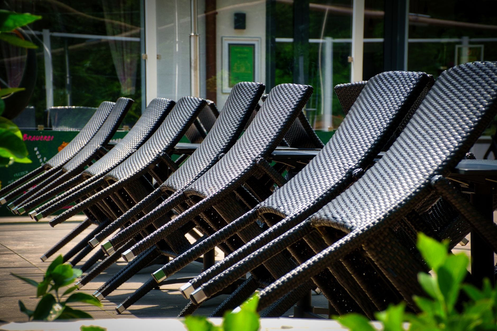 Rangée de chaises longues en résine tressée sur une terrasse ensoleillée