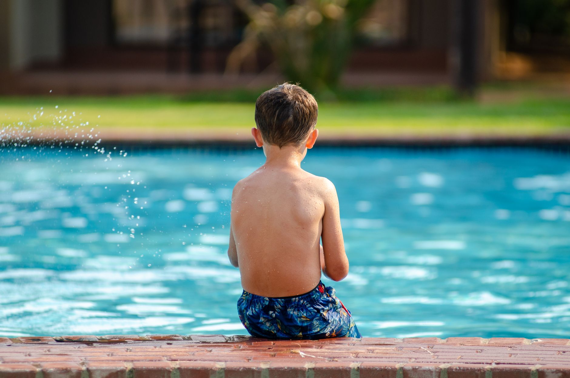 Enfant assis au bord de la piscine