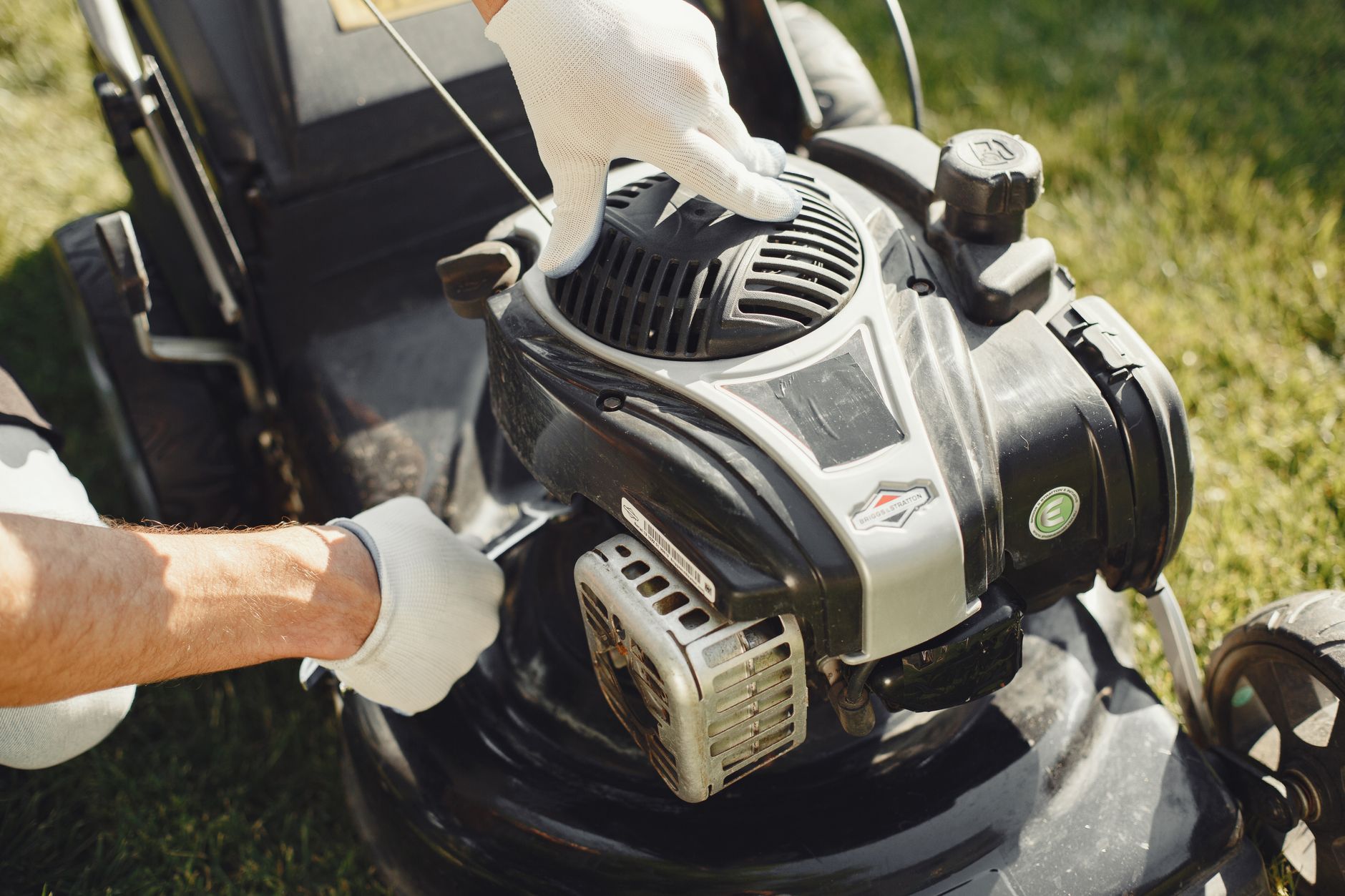 Reglage du moteur d une tondeuse avec des gants de jardinage