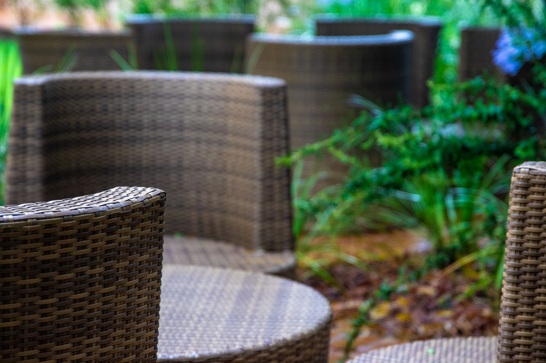 Table et chaises en textilène tressé posées sur une terrasse