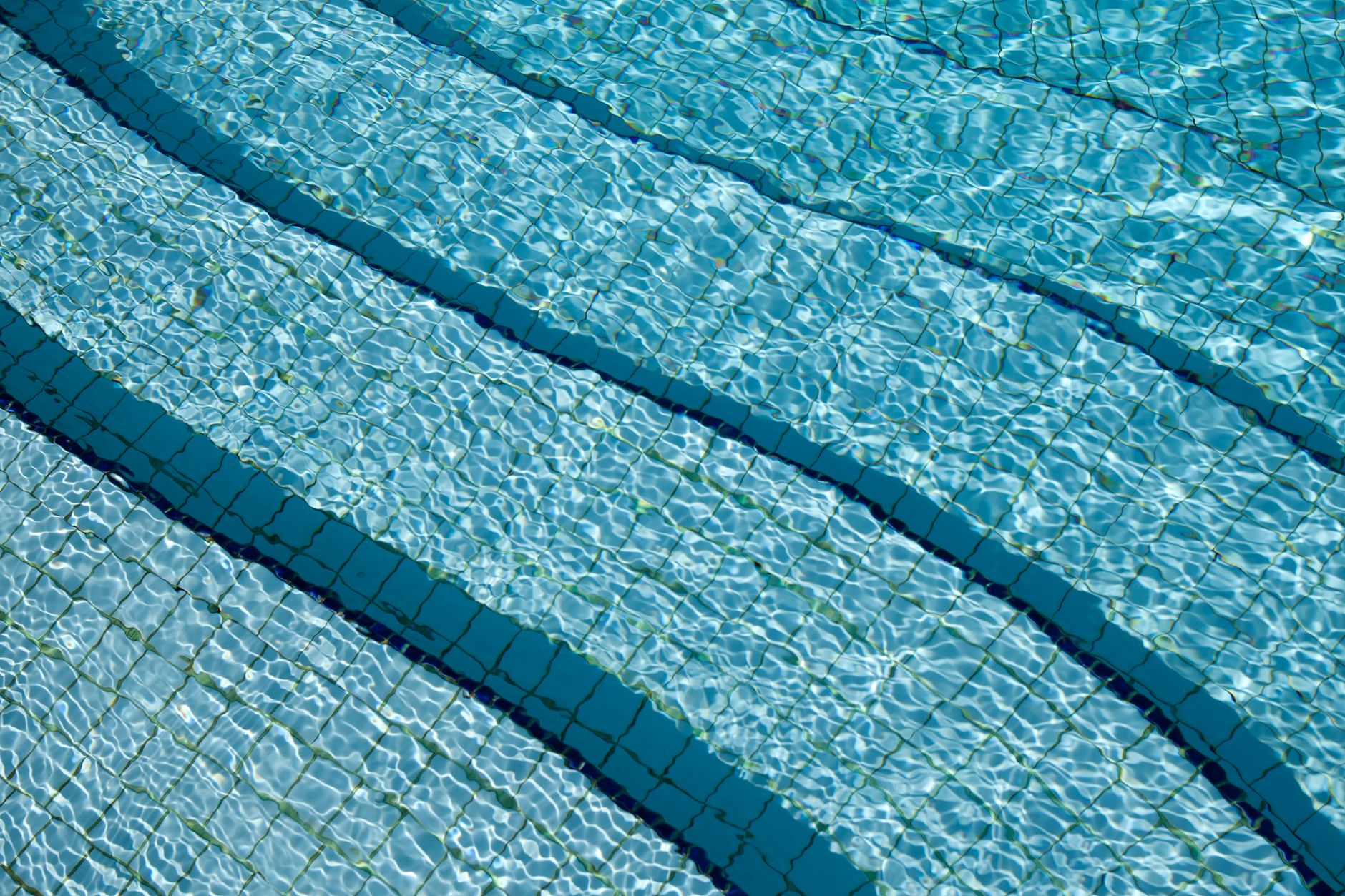 Eau limpide au-dessus du carrelage d’une piscine