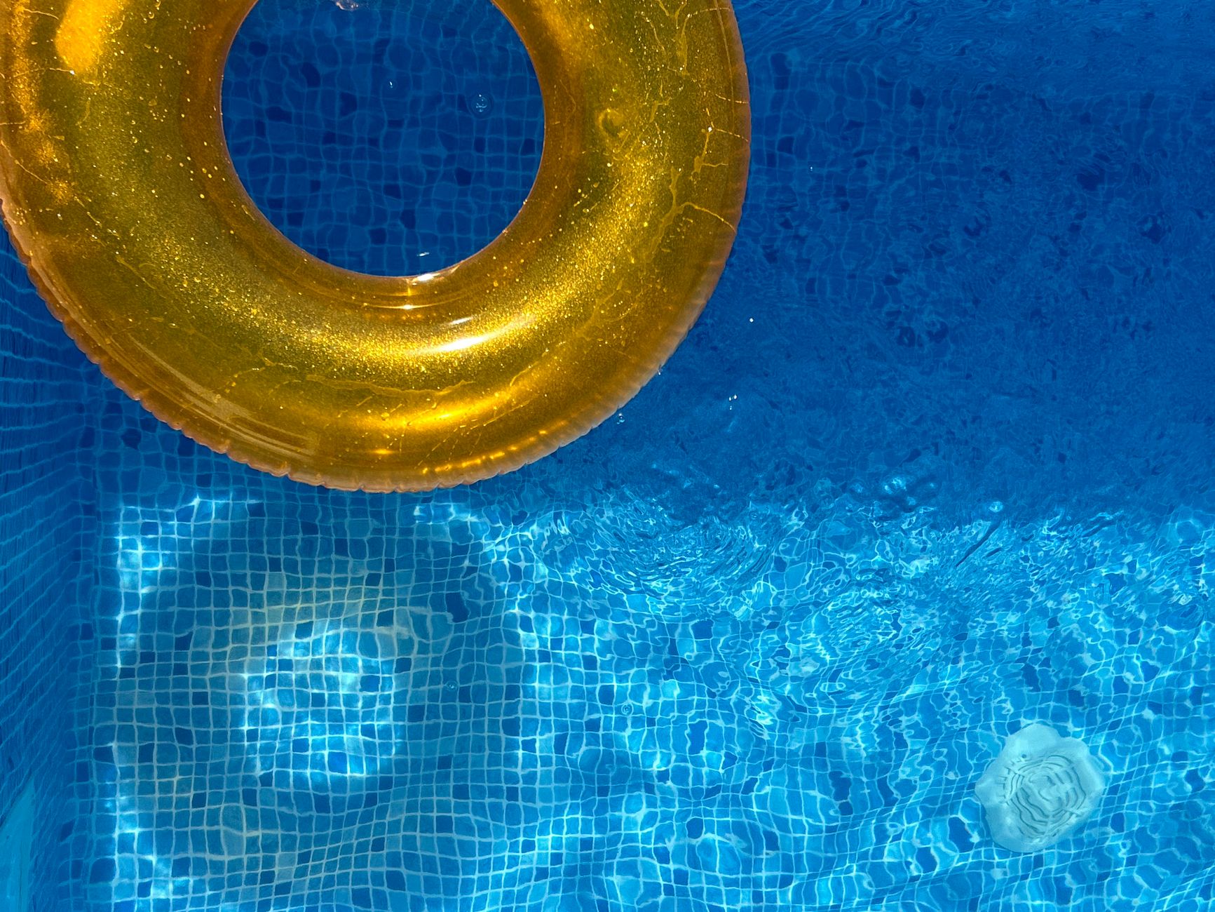 Bouée jaune posée sur une eau bleue de piscine
